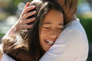 mother hugging her happy daughter