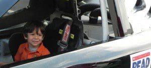 A VPK student sits in awe in a real-life race car, December 18, 2012 (Photo: ELCOC)