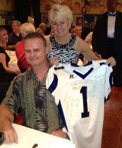 Tracey Stockwell, CFO Universal Orlando proudly displays a Dr. Phillips Football jersey memorabilia - an auction item - and husband Chip Stockwell, DP Youth Football Commissioner, May 4, 2013 (Photo: WONO)
