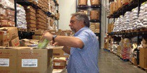 Dave Krepcho - President & CEO, Second Harvest Bank, checks the contents of food inside a box at the storage facility at the Main Office,