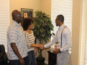 Personal touch. Focus 9 Enterprises C.E.O. Akil Yisrael greets two of his clients in Deltona recently. (Karsceal Turner-WONO).