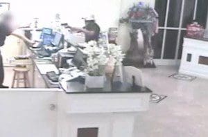 Video still of armed gunman at Quality