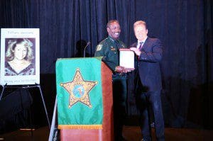 Orange County Sheriff Jerry Demings (l) presents Attorney Dan Newlin (r) with a plaque in recognition of his continuous support of the annual Sheriff's Office Community Crime Summit. A poster of 20-year-old Tiffany Sessions of Gainesville, FL, missing since February 1989 is displayed. Missing and exploited children was one of the topics discussed at the '2014 Sheriff's Office Community Crime Summit, on September 29, 2014. in Orlando.